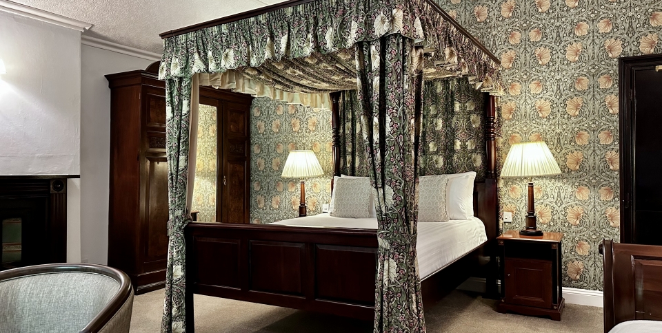 A larger room with a 4-poster at the back of the hotel